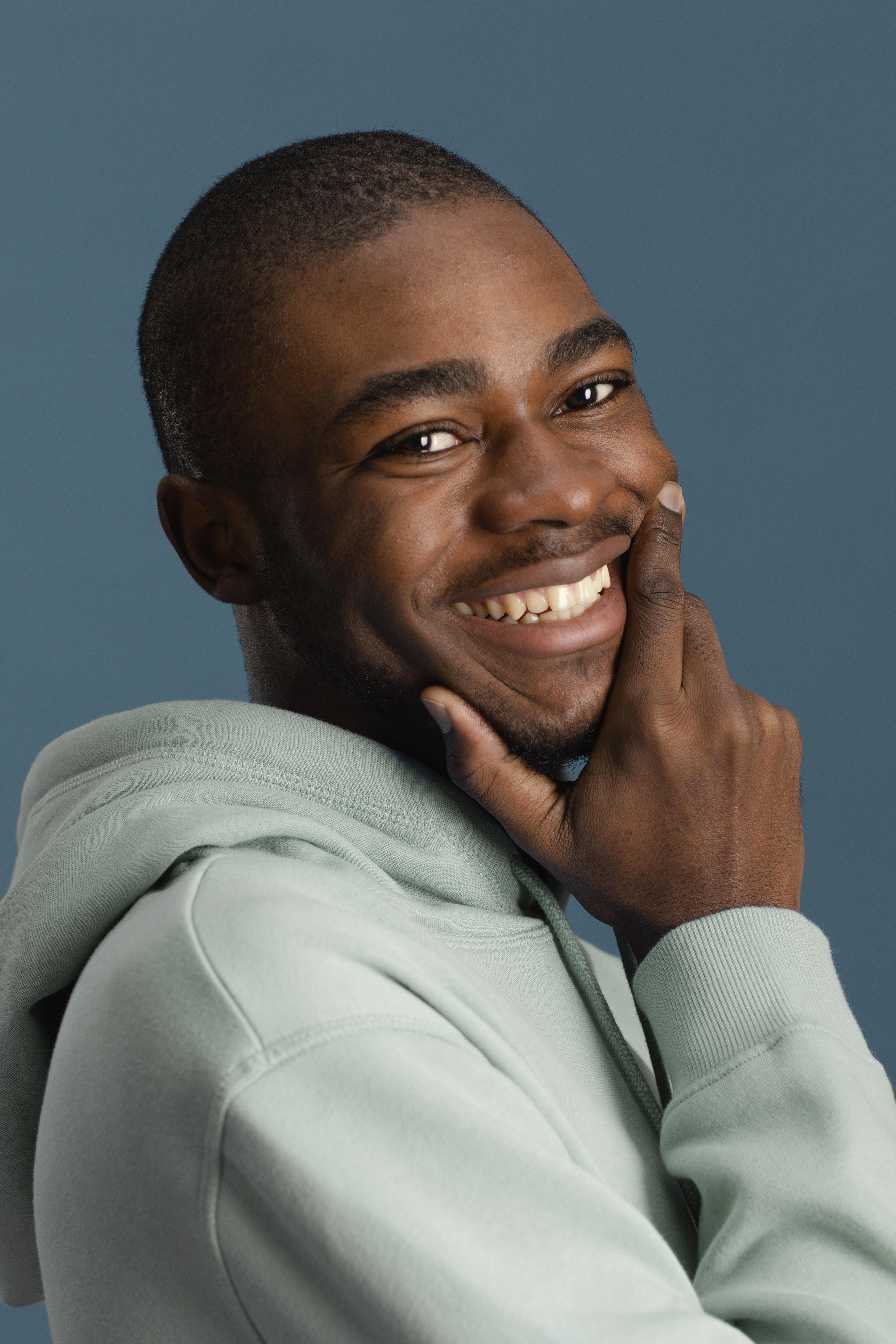 Smiling man in a sage green hoodie